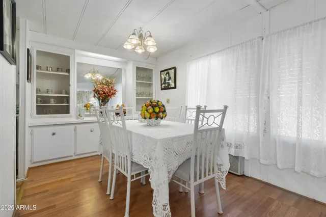 a dining room with furniture a chandelier and wooden floor