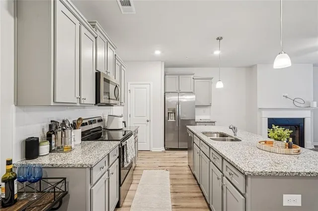 a kitchen with granite countertop stainless steel appliances a sink stove and refrigerator