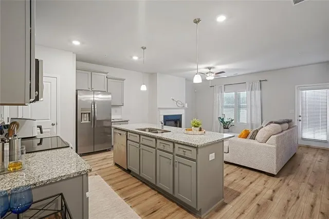 a kitchen with stainless steel appliances granite countertop a sink stove and refrigerator
