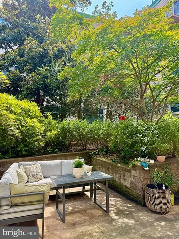 a roof deck with table and chairs and potted plants