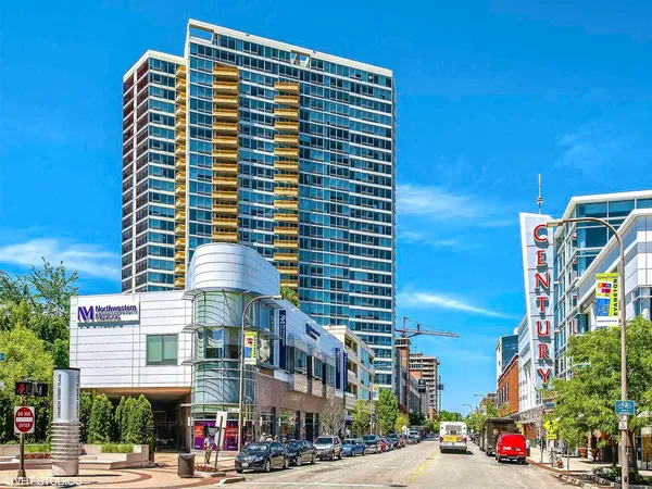 a front view of a building with street view and trees