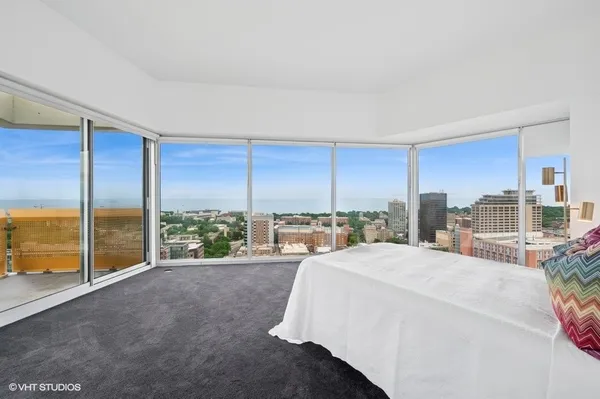 a spacious bedroom with a large window and a bed