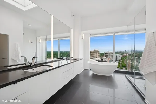 a large white kitchen with a sink and large window