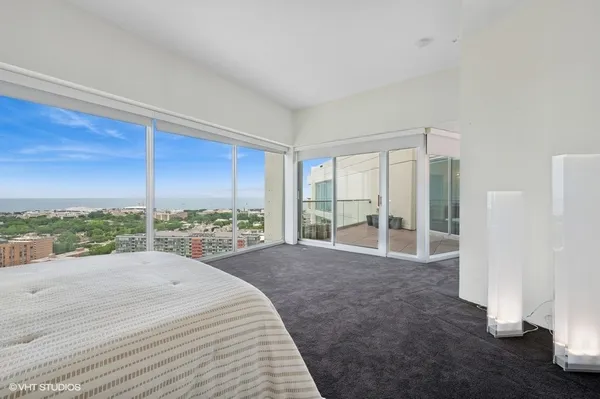 a spacious bedroom with a large window and a balcony