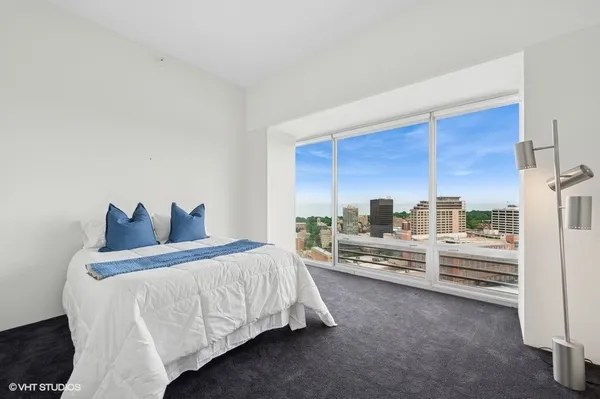 a room with a bed and a large window