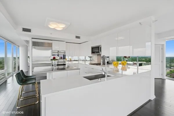 a kitchen with stainless steel appliances lots of counter top space and furniture
