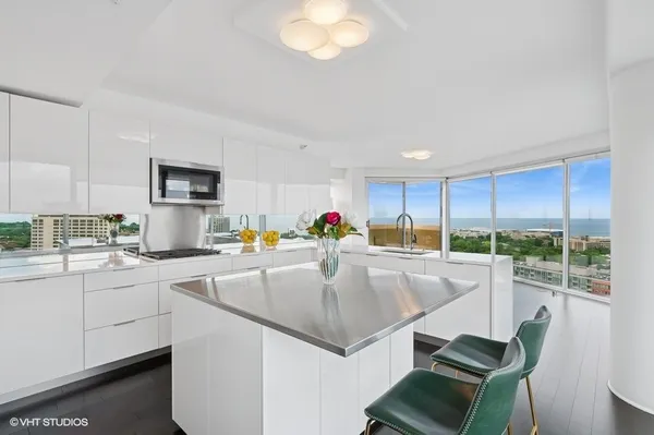 a kitchen with stainless steel appliances granite countertop a sink a stove and a microwave