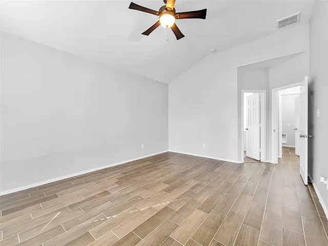 an empty room with a window and ceiling fan