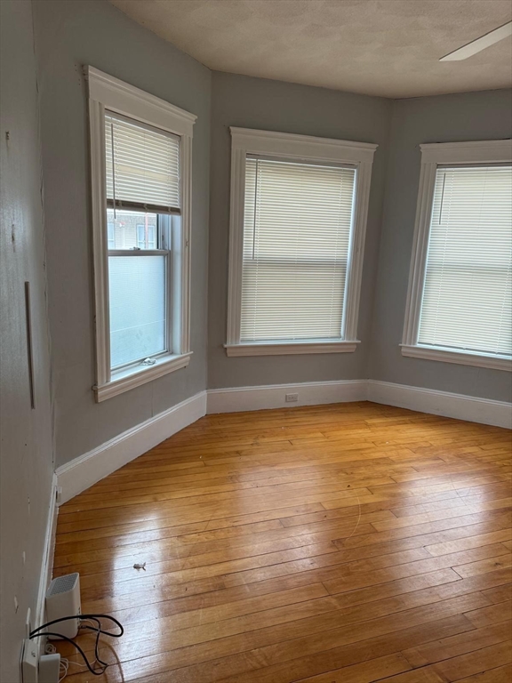 25 Seafoam Avenue, Unit 1 Winthrop, MA 02152 - Photo 15 of 17 a view of an empty room with wooden floor and a window