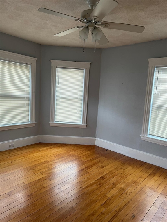 25 Seafoam Avenue, Unit 1 Winthrop, MA 02152 - Photo 16 of 17 an empty room with wooden floor fan and windows