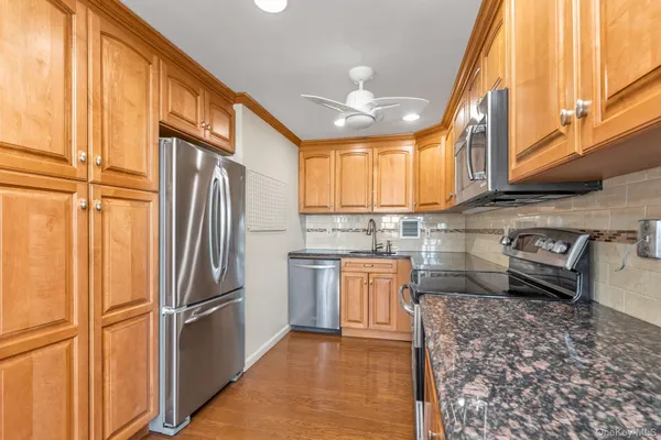 a kitchen with stainless steel appliances granite countertop a refrigerator a sink a stove and island