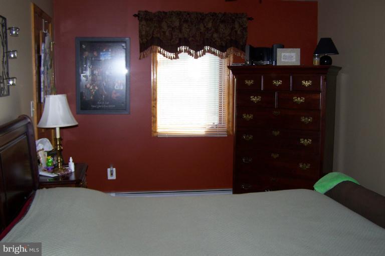 a bedroom with a bed and a lamp on dresser