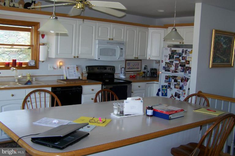 2005 Shore Drive Edgewater, MD 21037 - Photo 20 of 29 a kitchen with stainless steel appliances granite countertop a sink dishwasher a stove a dining table and chairs with wooden floor
