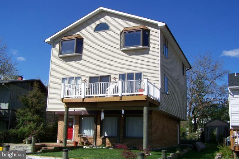 2005 Shore Drive Edgewater, MD 21037 - Photo 6 of 29 a front view of a house with lots of windows and trees