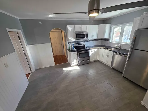 a kitchen with stainless steel appliances granite countertop a refrigerator a stove top oven a sink and dishwasher
