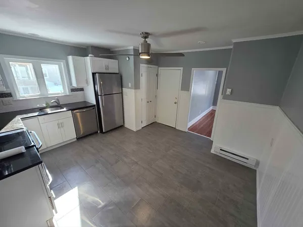 a view of a kitchen with fridge and wooden floor