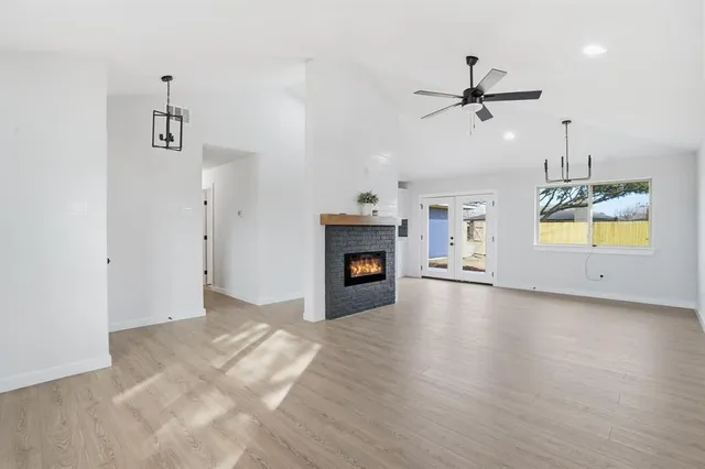 a view of an empty room with a fireplace and a window