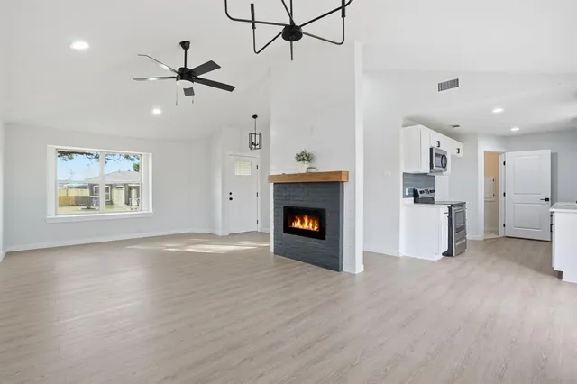 a view of an empty room with a fireplace and a window
