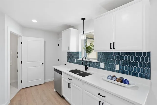 a kitchen with stainless steel appliances kitchen island granite countertop a sink a stove and a wooden floors