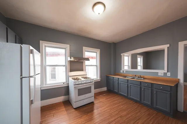 a large kitchen with stainless steel appliances granite countertop a stove and a refrigerator