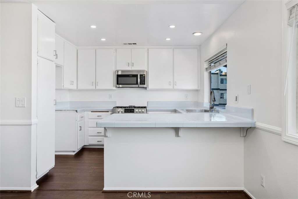 428 West First Street Tustin, CA 92780 - Photo 11 of 35 a kitchen with stainless steel appliances a sink stove and white cabinets