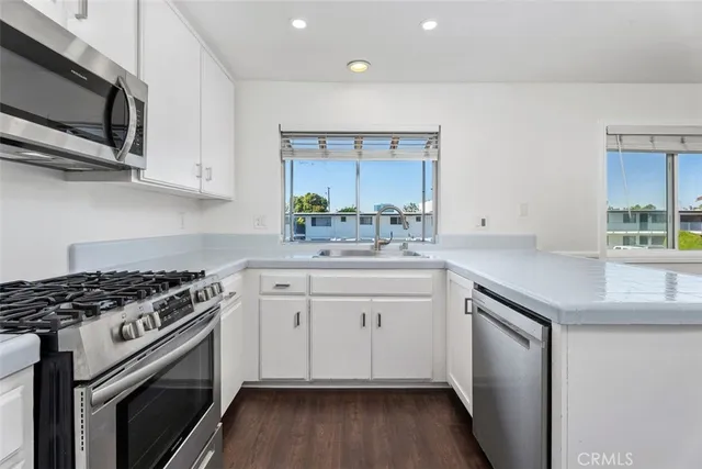 a kitchen with stainless steel appliances a sink stove and cabinets