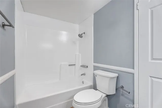 a white toilet and tub next to a white cabinet