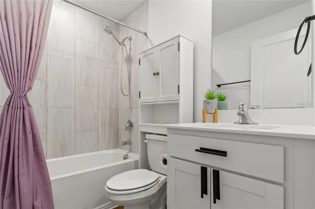 a bathroom with a sink a toilet a tub and shower