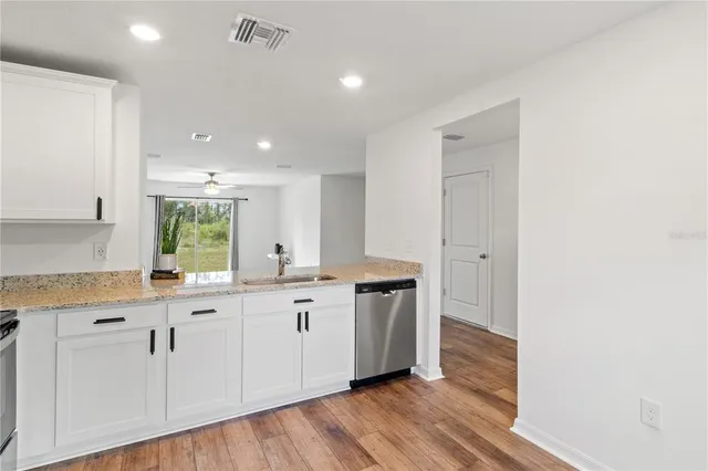 a large kitchen with cabinets and wooden floor