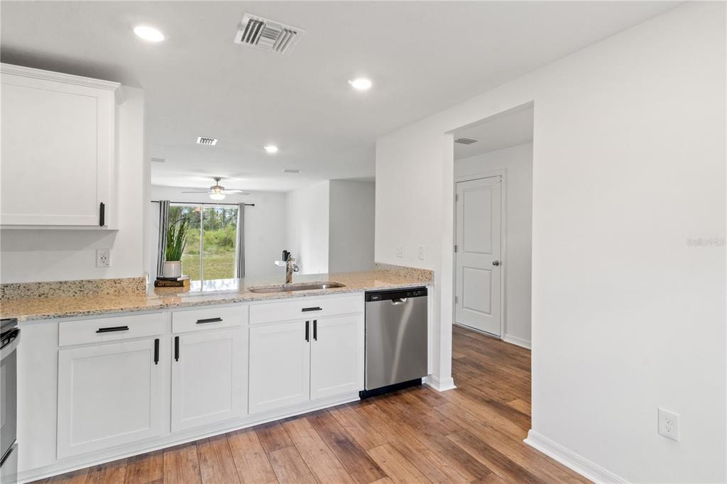 11380 Old Squaw Avenue Weeki Wachee, FL 34614 - Photo 6 of 23 a large kitchen with cabinets and wooden floor