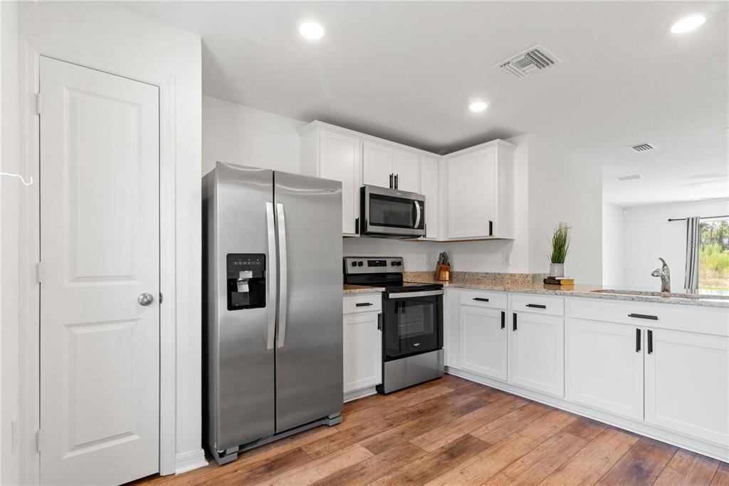 11380 Old Squaw Avenue Weeki Wachee, FL 34614 - Photo 8 of 23 a kitchen with granite countertop a refrigerator stove top oven and sink