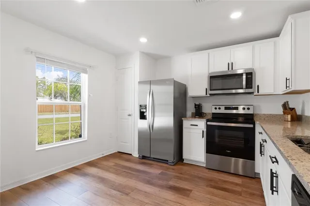 a kitchen with stainless steel appliances granite countertop a stove a refrigerator and a stove top oven