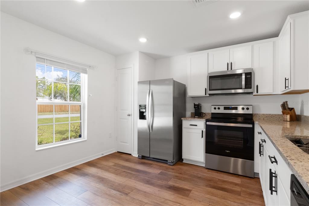 11380 Old Squaw Avenue Weeki Wachee, FL 34614 - Photo 9 of 23 a kitchen with stainless steel appliances granite countertop a stove a refrigerator and a stove top oven
