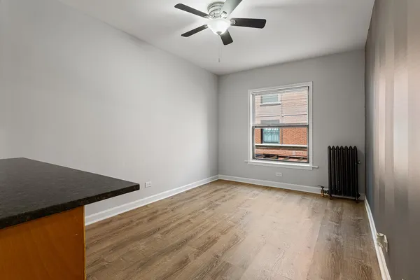an empty room with windows and fan