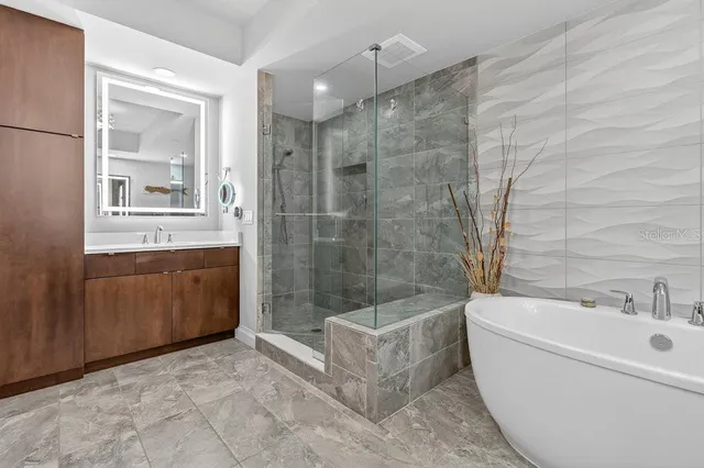 a spacious bathroom with a tub sink and mirror