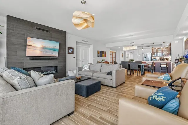 a living room with furniture kitchen view and a large window