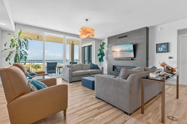 a living room with furniture kitchen view and a large window