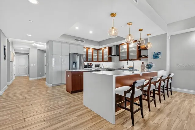 a kitchen with stainless steel appliances kitchen island granite countertop a table chairs sink and cabinets
