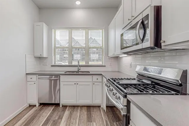 a kitchen with granite countertop a sink stove and cabinets