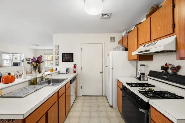 a kitchen with stainless steel appliances a sink stove and refrigerator