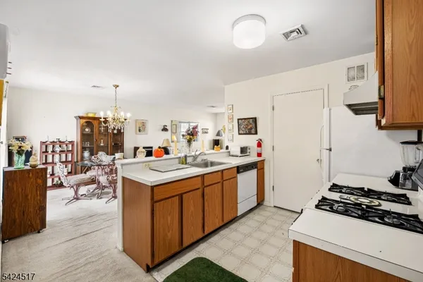 a kitchen that has a lot of white cabinets and stainless steel appliances