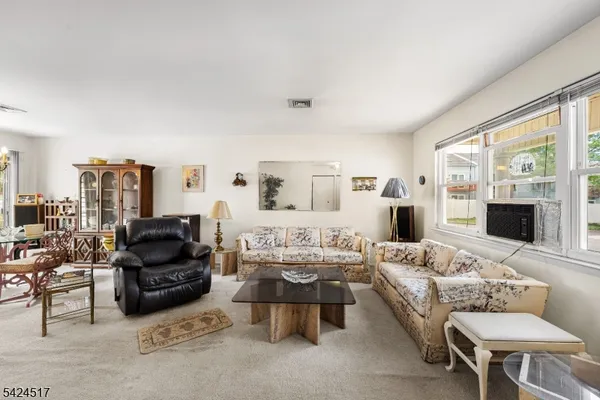 a living room with furniture fireplace and a large window
