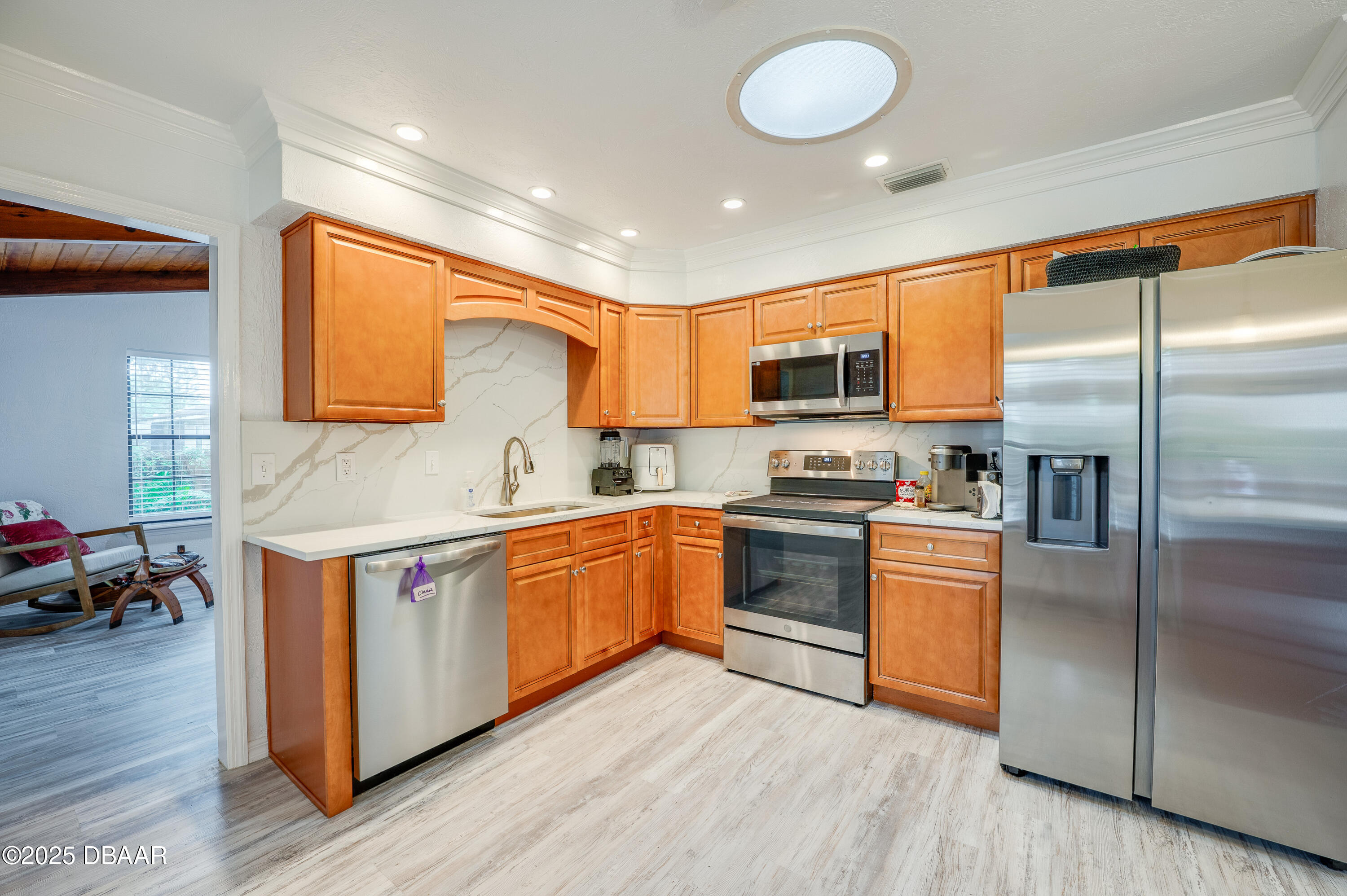 2824 Umbrella Tree Drive Edgewater, FL 32141 - Photo 23 of 36 a kitchen with stainless steel appliances granite countertop a stove a sink dishwasher a refrigerator and a microwave oven with wooden floor
