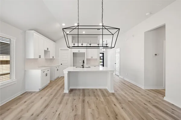a view of kitchen with stainless steel appliances granite countertop a sink and wooden floor