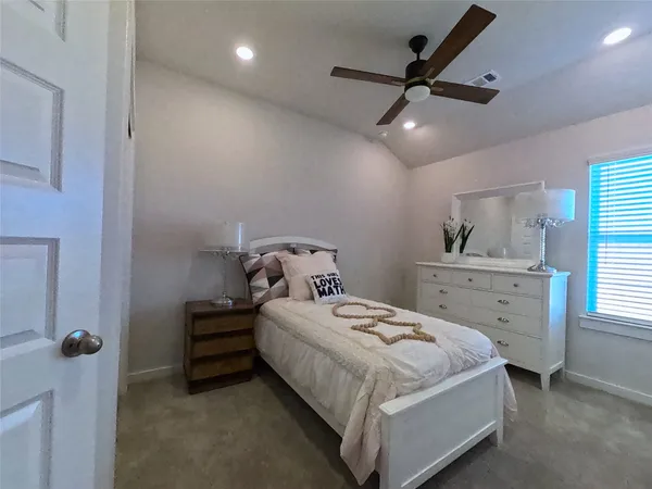 a bedroom with a bed wooden floor and window
