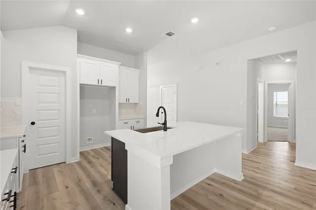 a view of a kitchen cabinets a sink and wooden floor