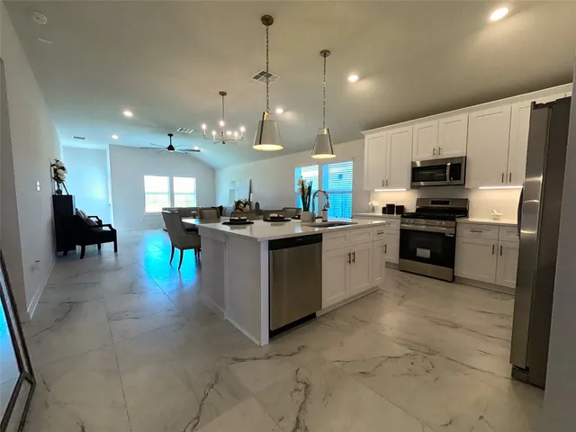 a kitchen with a stove a refrigerator and a dining table