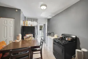 a kitchen with stainless steel appliances granite countertop a stove a refrigerator a sink a dining table and chairs with wooden floor