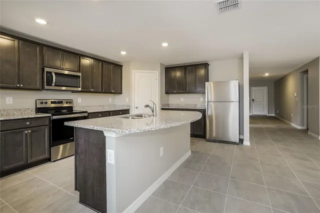 a kitchen with kitchen island a sink stainless steel appliances and cabinets