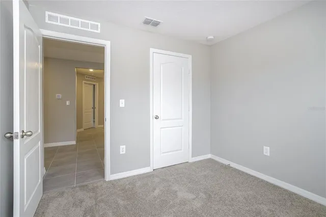 an empty room with closet and a bathroom